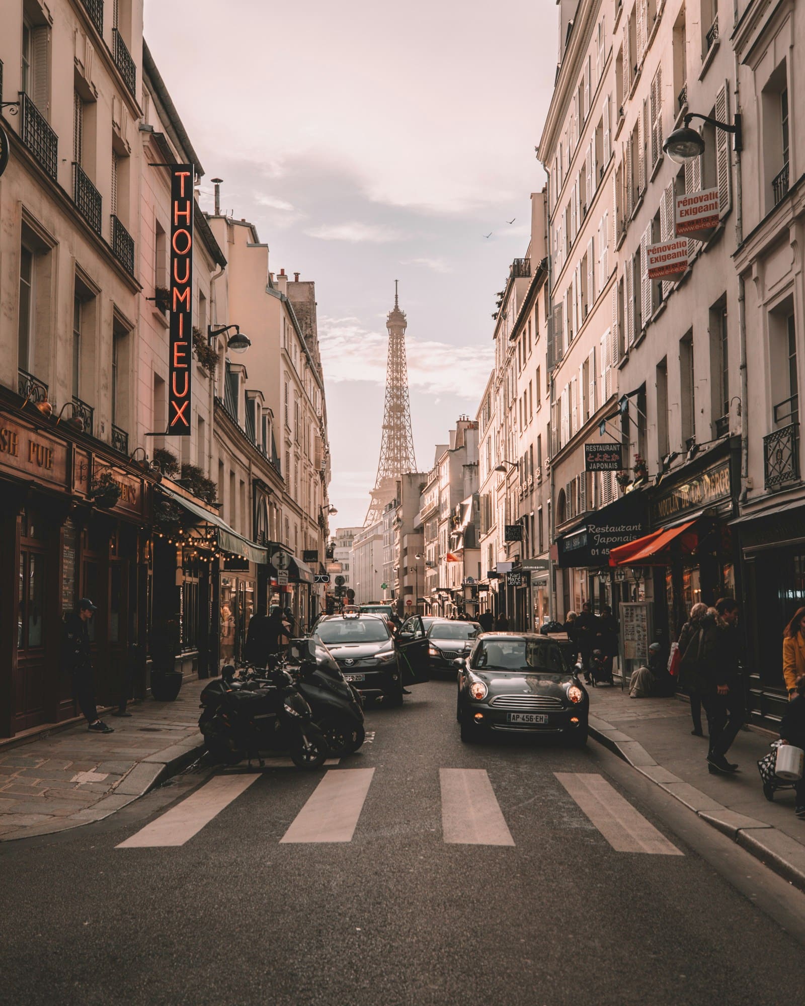 A Paris street at golden hour with the Eiffel Tower at the end of it