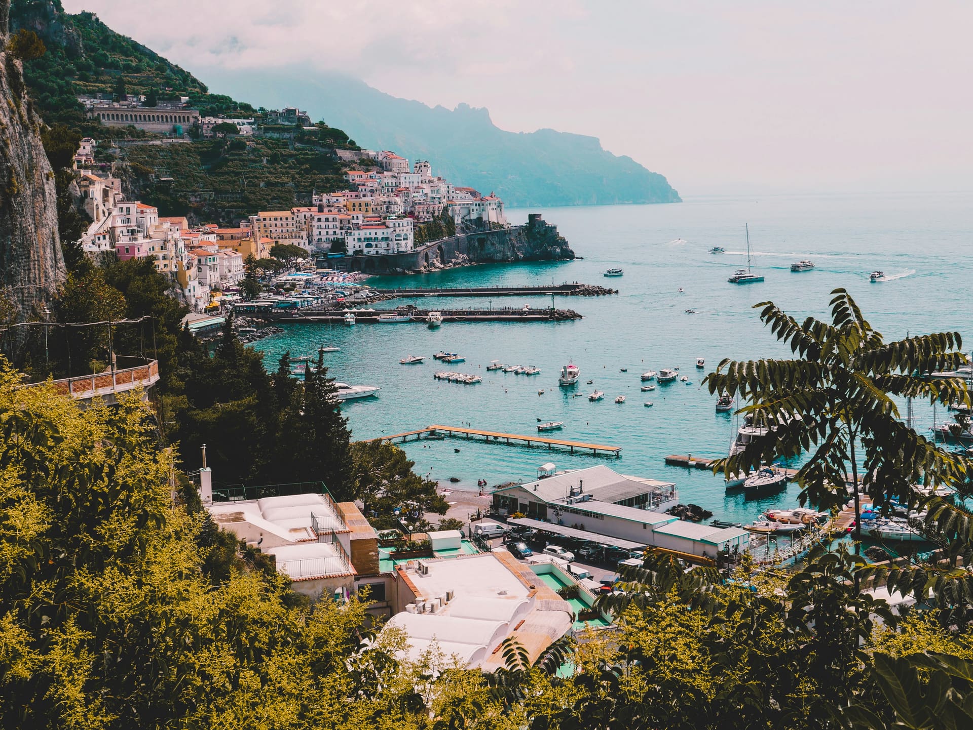 The cliffside town of Amalfi above a harbour full of small boats