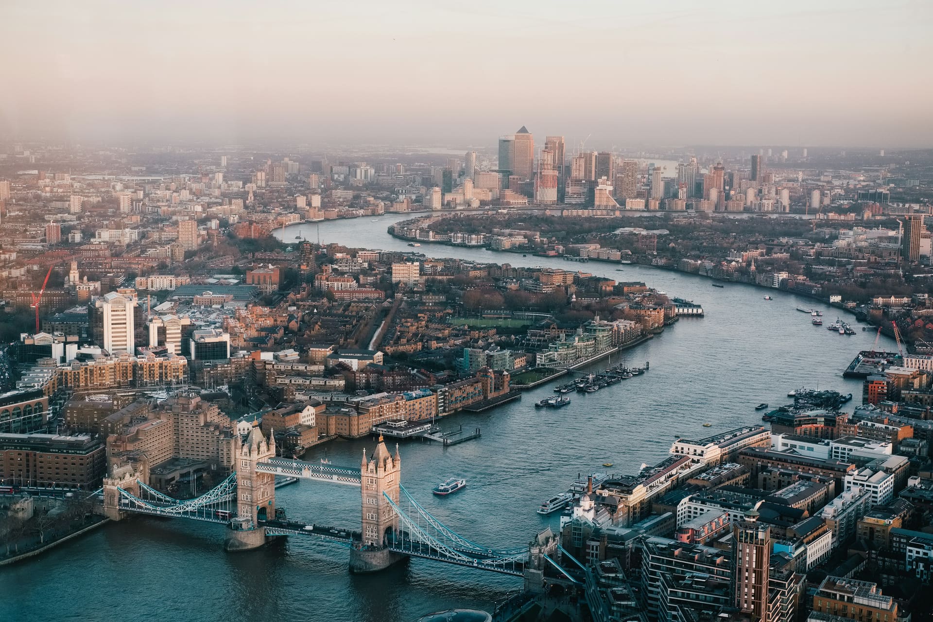 Tower Bridge and the Thames winding through London at sunrise